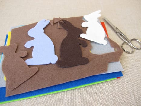 Easter bunnies cut out of colorful felt with scissors
