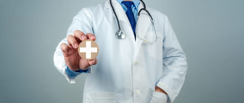 Doctor showing circle wood plank and plus sign represents medical health care and doctor staff service concept, Insurance in health care and medicine concept.