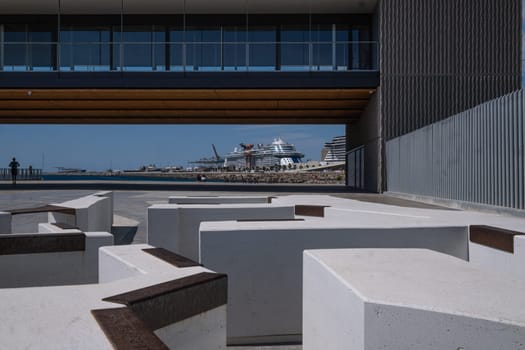 Overview of Barcelona's port area photographed from the Rambla del Rompeolas (Breakwater Avenue) promenade, with the Mirador building in the foreground. A new space usable by citizens, part of a renovation of Barcelona's Port Vell that has transformed the spaces surrounding the new port mouth.