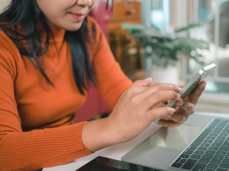 Asia women working business SME online at home her checking order from smartphone  for customer and online delivery for ready packing, Checking orders from customers with digital laptop.