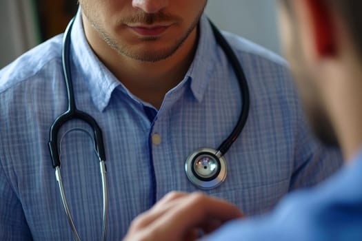 Bearded doctor in blue shirt examining patient, focus on stethoscope.