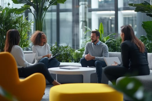 Professional team in conversation surrounded by plants in bright, contemporary office space.