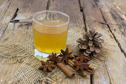 Apple juice, cinnamon sticks and anise stars on wooden background