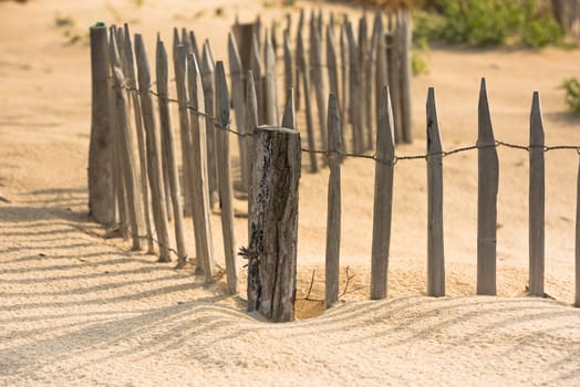 Wooden fence on an Atlantic beach in France, The Gironde Department. Shot with a selective focus