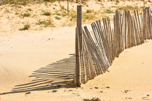 Wooden fence on an Atlantic beach in France, The Gironde Department. Shot with a selective focus