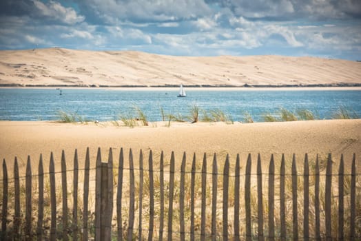 Wooden fence on an Atlantic beach in France, The Gironde Department. Shot with a selective focus