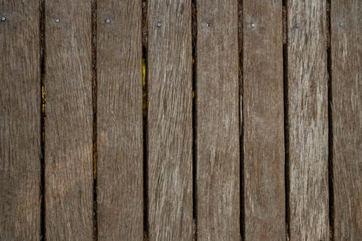Close up of old abandoned rickety foot bridge. Old wood texture background coming from natural tree. The wooden panel has a beautiful dark pattern.