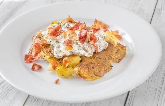 Smashed potatoes with bacon and sour cream sauce