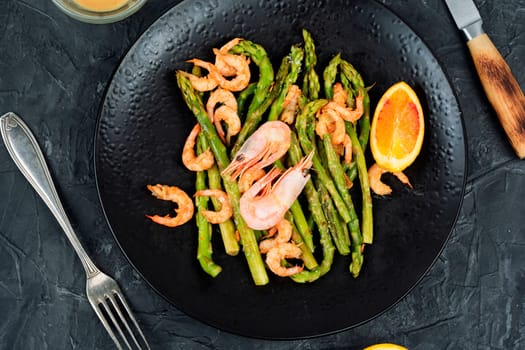 roasted shrimp with green asparagus. Seafood menu.