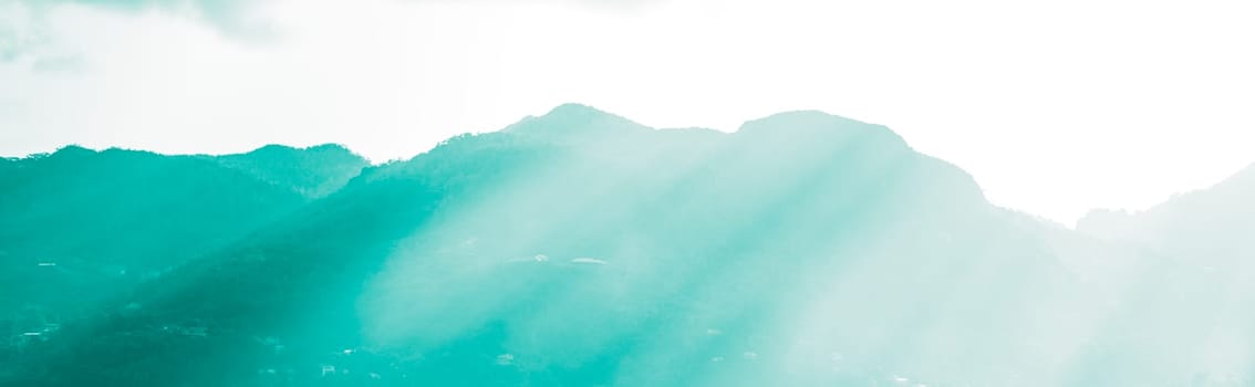 Mountains and bright sun light beams. Defocused Beautiful summer landscape with filter.