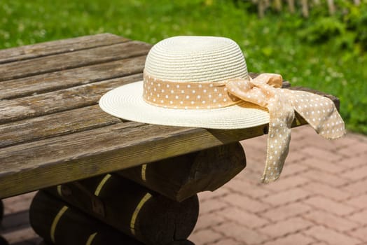 Female summer hat laying on the wooden rustic table. Selective focus shot