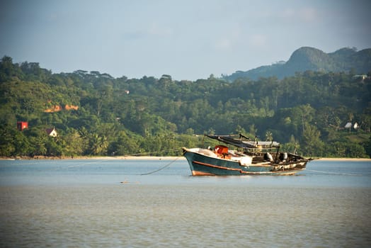 View of Seychelles coastline with an old boat on a foreground. Horizontal shot