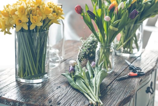 Spring flowers on a wooden table. Indoors natural light shot with small depth of field