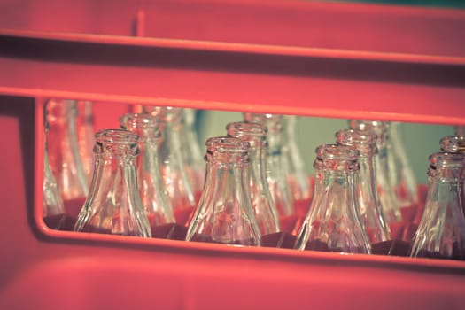 Red Plastic Crate with Empty Glass Bottles. Horizontal filtered shot