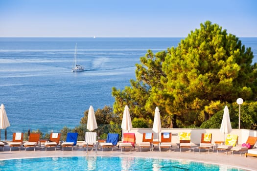 Sunbeds and umbrellas by the swimming pool on a sunny day