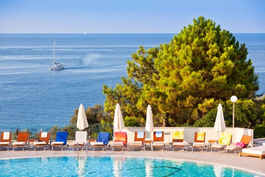 Sunbeds and umbrellas by the swimming pool on a sunny day