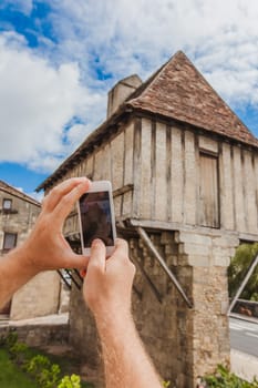Tourist hands holding smart phone taking photo of Perigueux, France