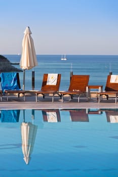 Sunbeds and umbrellas by the swimming pool on a sunny day