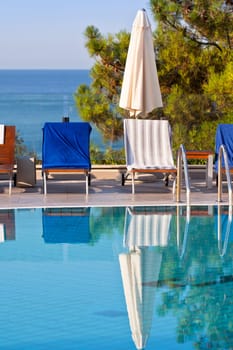 Sunbeds and umbrellas by the swimming pool on a sunny day