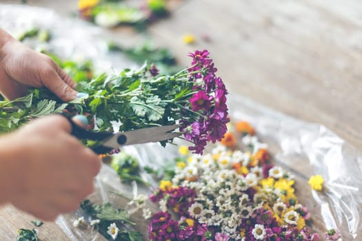 Florist making flower decoration. Indoors natural light shot with small depth of field
