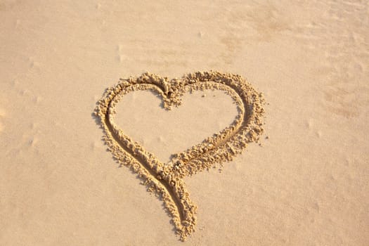 shape of heart paint on sea sand. horizontal shot