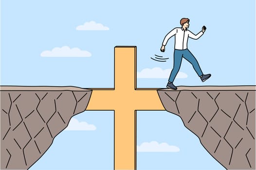 Religious business man overcomes obstacles thanks to christian crucifix and achieves goal. Guy corporate manager, is practicing catholic and achieves success in career using christian commandments.