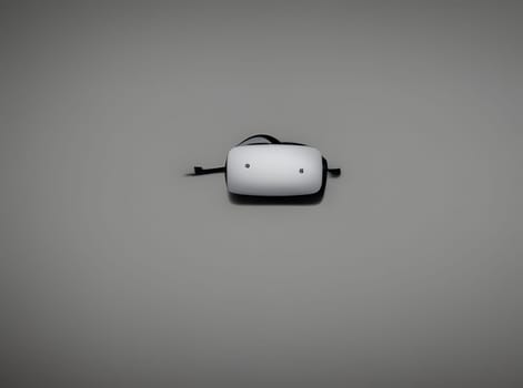 A small, sleek wireless device sits on a plain surface, showcasing its modern design. Its minimalistic features emphasize the technology's functionality.