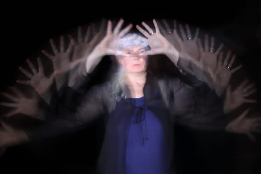 Long exposure at night of a woman waving her hands