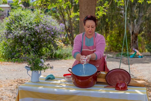 Andalucia, Spain: April 17, 2024: A woman works making Pecorino cheese. Handmade cheese making near Granada, Spain
