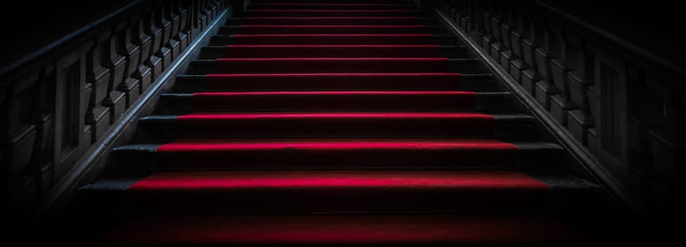 Vintage dark staircase with red carpet