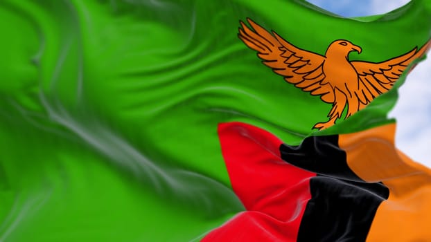 Close-up of Zambia national flag waving in the wind. Green with an orange eagle in flight over a block of three vertical stripes in red, black, and orange. 3d illustration render. Selective focus