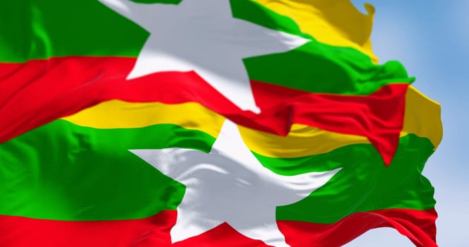 Close-up of two Myanmar national flags fluttering. Flag has horizontal yellow, green, red stripes with white 5-point star in the middle. 3D illustration render. Close-up. Selective focus.