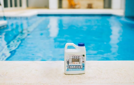 Clarifier on the edge of a crystal clear swimming pool. Clarifying chemical on the edge of a beautiful swimming pool