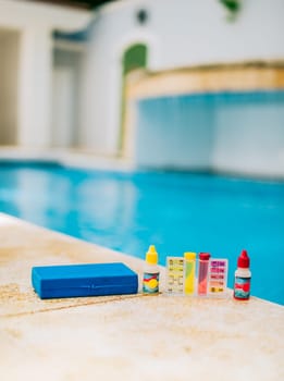 Chlorine and ph tester for swimming pools. Water test kit on the edge of the swimming pool. Chlorine test kit for swimming pools