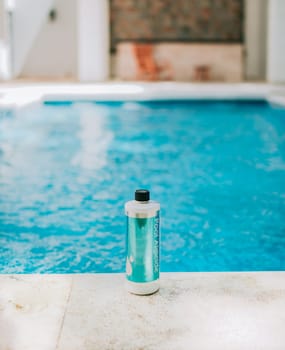 Bottle of algicide for cleaning home pools. Algicide powder for cleaning and purifying swimming pools