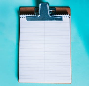Top view of notepad on isolated background. Note book on clipboard on color background
