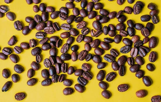 Coffee beans on yellow background. Roasted coffee beans with yellow background