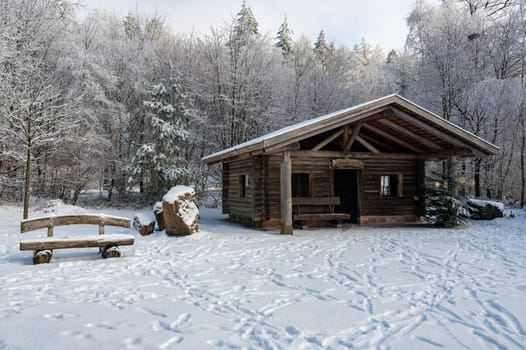 A log cabin in winter with lots of snow and trees