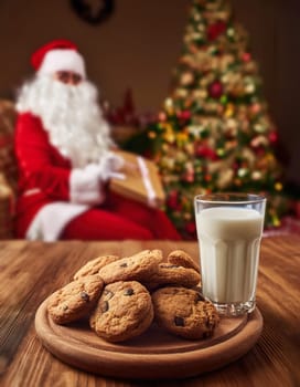 Cookies snacks and milk glass on the table prepared for Santa Claus in the Christmas Eve night