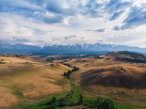 Kurai steppe and Chuya river on North-Chui ridge mountains background. Altai mountains, Russia. Aerial drone panoramic picture.