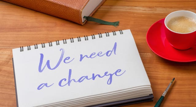 Notepad on a desk - We need a change