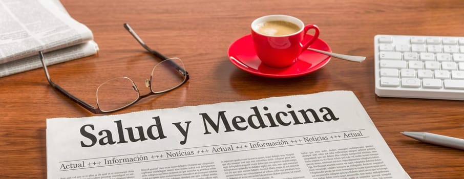 A newspaper on a wooden desk - Health and Medical in spanish