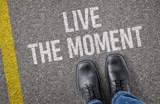 Text on the road - Live the moment
