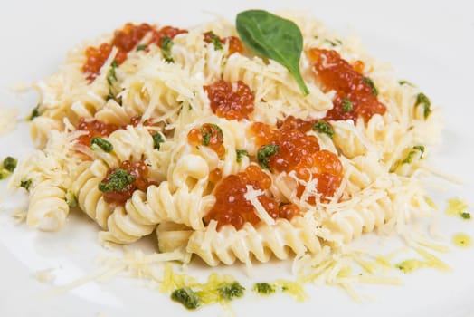 Pasta with parmesan cheese basil and red caviar. The concept of Italian cuisine.