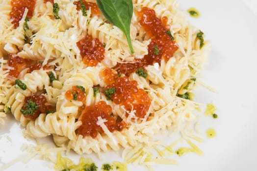 Pasta with parmesan cheese basil and red caviar. The concept of Italian cuisine.