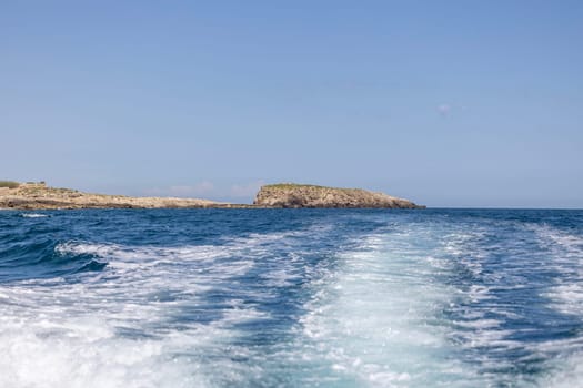 View from the water of picturesque coastline with cliffs and caves by Adriatic Sea, Polignano a Mare, Italy, Apulia. Boat cruise along the rocky coast is a great tourist attraction