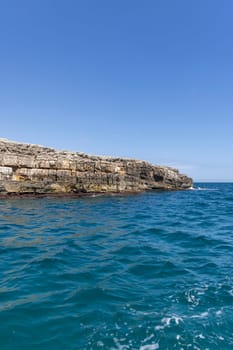 View from the water of picturesque coastline with cliffs and caves by Adriatic Sea, Polignano a Mare, Italy, Apulia. Boat cruise along the rocky coast is a great tourist attraction