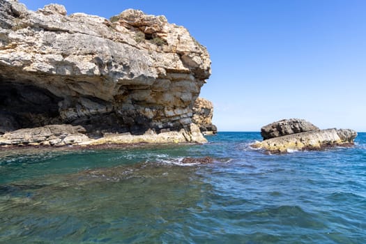 View from the water of picturesque coastline with cliffs and caves by Adriatic Sea, Polignano a Mare, Italy, Apulia. Boat cruise along the rocky coast is a great tourist attraction