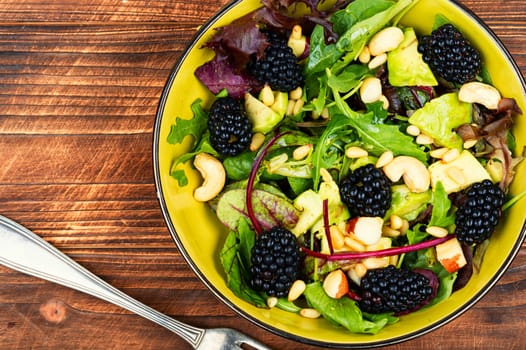 Clean food, salad with fresh blackberries and feta garnished with fresh herbs. Copy space, recipe place.