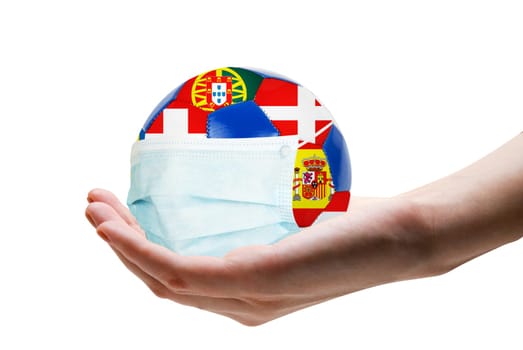 Euro cup football with nations flags and protective mask in hand. Virus threatened championship concept